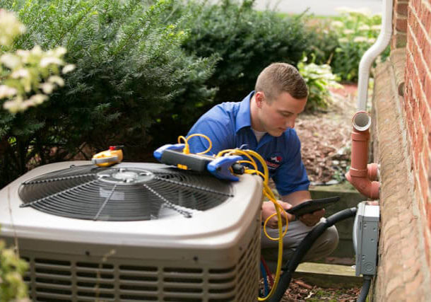 HVAC technician checks reading outside